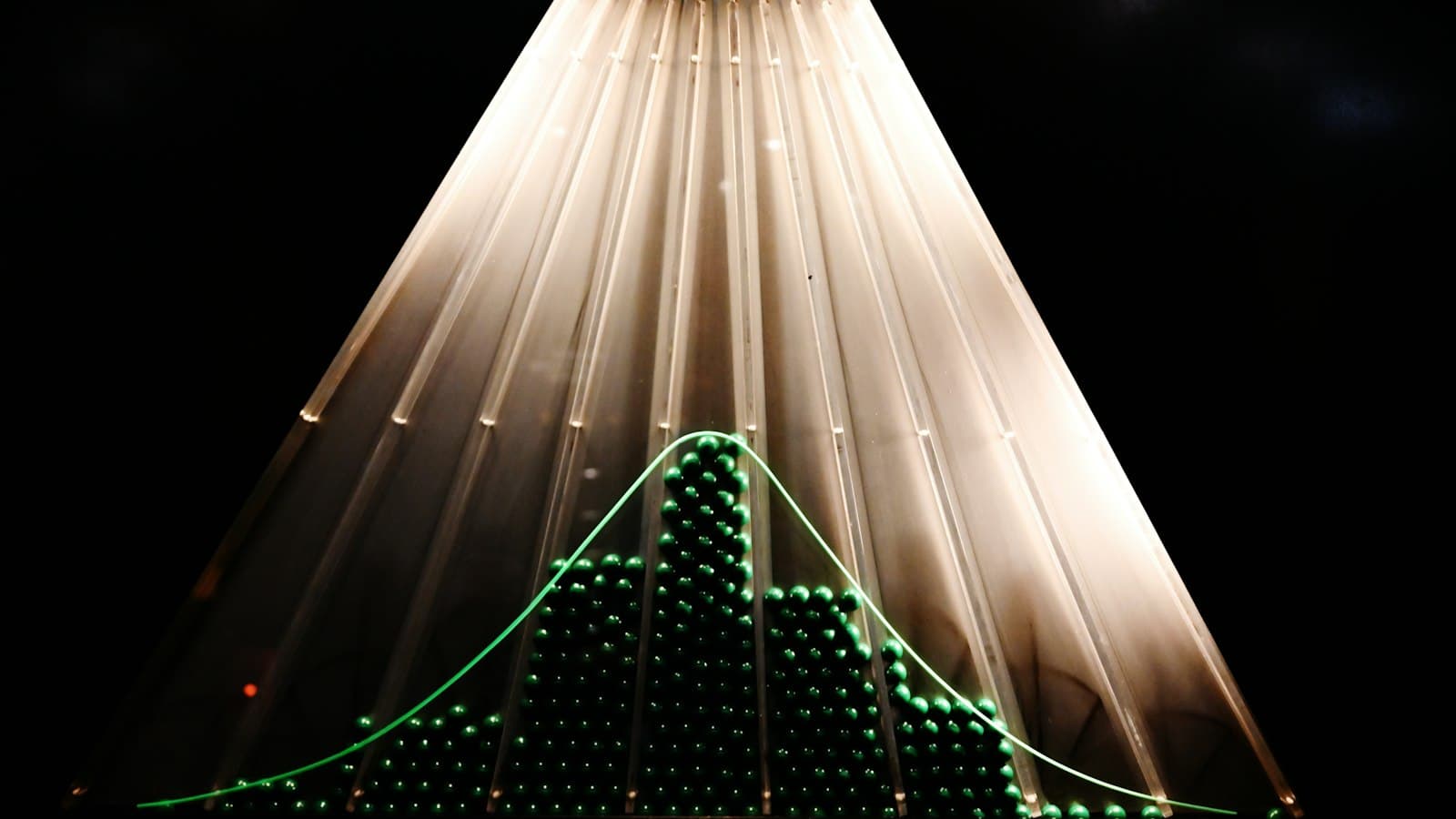 A physical bell curve graph with illuminated lights.