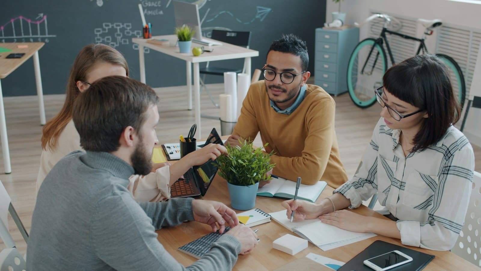 A diverse team collaborating around a table in a modern office.