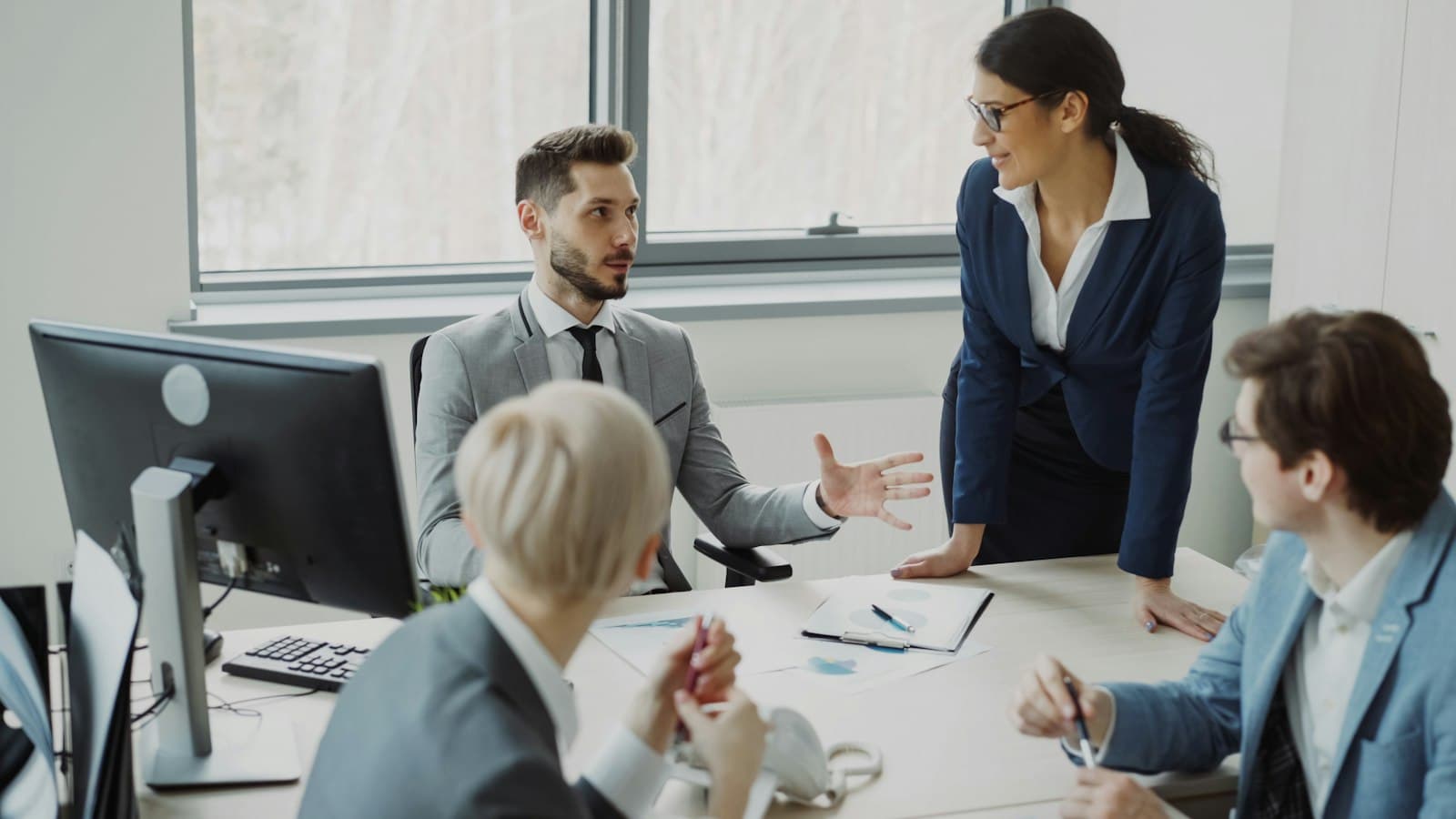 Business professionals collaborating around a table in a modern office meeting.
