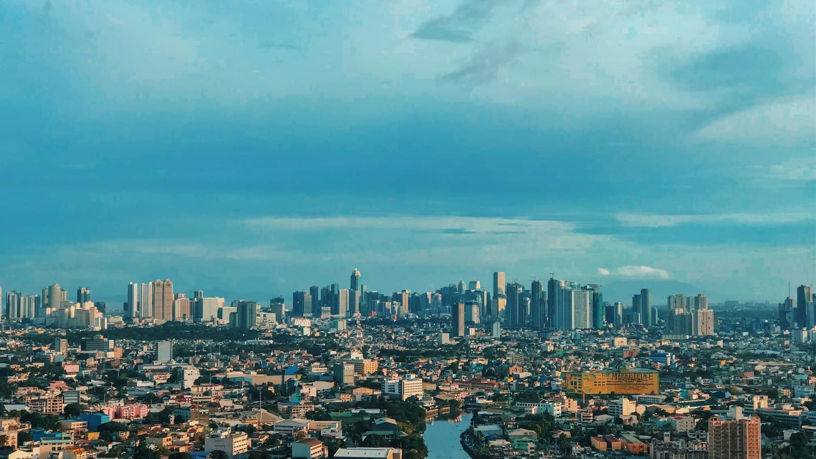 The Manila, Philippines city skyline under a blue sky.